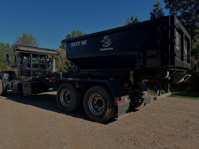 Truck with black dumpster for rent.